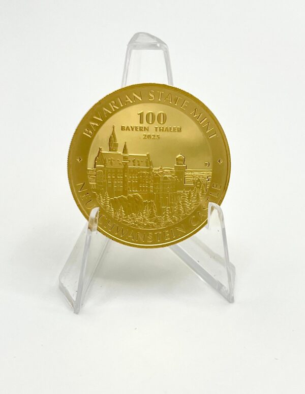 „100 Bayern Thaler“ in Gold, Motiv 2025 mit Neuschwanstein-Motiv. Vorderansicht, auf Münzhalter vor weißem Hintergrund. Ein Muss für Münzsammler und Liebhaber historischer deutscher Prägungen. Zeigt das berühmte Schloss Neuschwanstein. Ideal als Geschenk oder Wertanlage