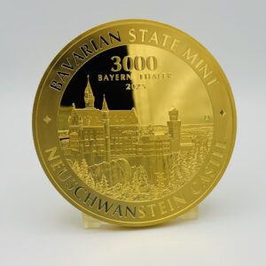 1 Kilo Gold Bayern Thaler vor weiss-grauem Hintergrund. Motiv Neuschwanstein, Jahrgang 2025.