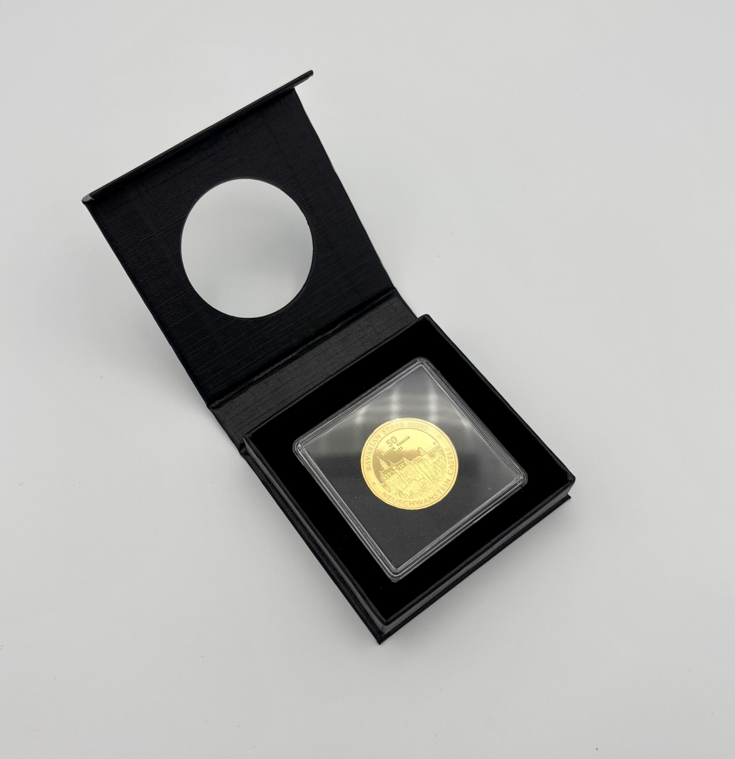 "50 Bayern Thaler" in Gold in schwarzen Airbox Etui vor weißem Hintergrund