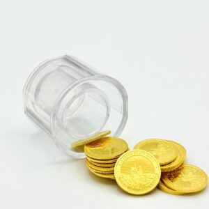 25 goldene Bayern Thaler aus geschüttet neben einem transparenten Tube. Weiß-grauer Hintergrund.