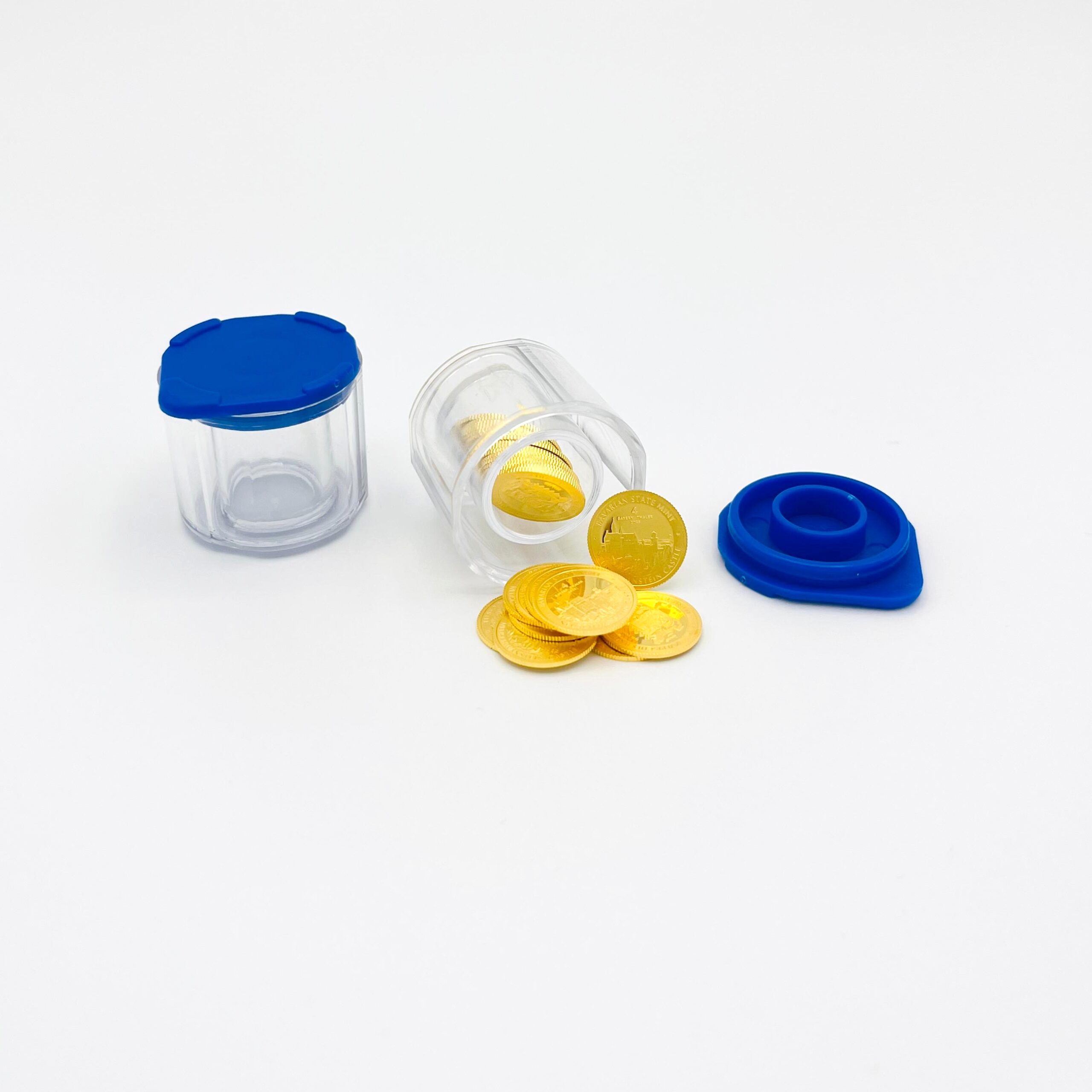 Kleines Tube aus Plexiglas gefüllt mit 25 Stück "4Bayern Thalern" - ausgekippt vor weißem Hintergrund. Daneben Deckel und ein leeres Tube.