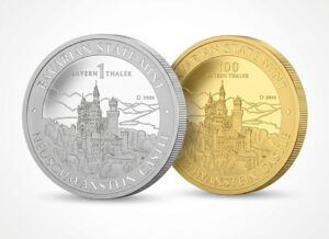 Gold und Silber Bayern Thaler vor weißem Hintergrund. Auf den Thalern ist jeweils das Schloss Neuschwanstein zu sehen.